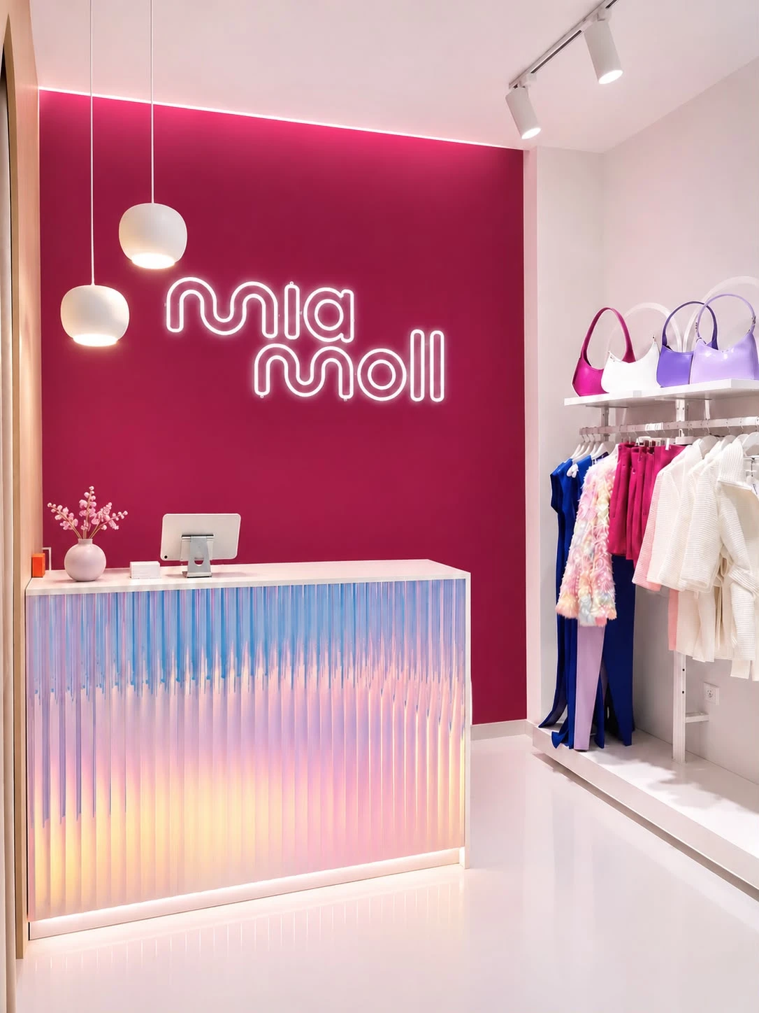 Mostrador de la boutique con el logo de Mia Moll en neón sobre la pared fucsia